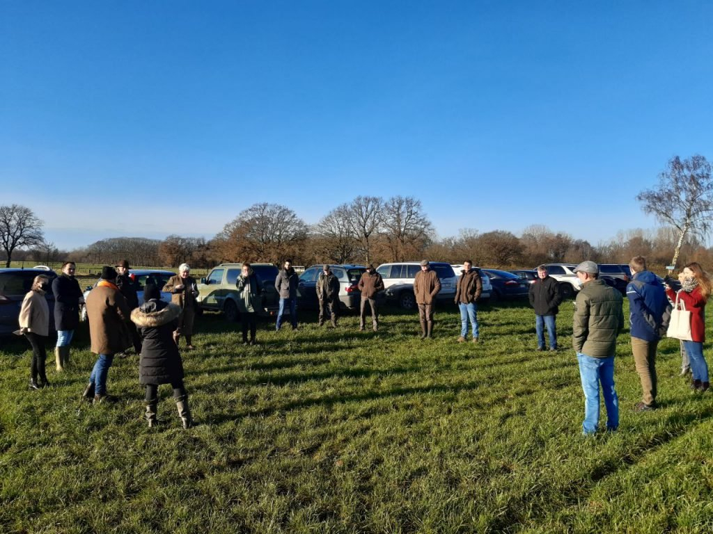 Mensen staan in cirkel op een grasveld